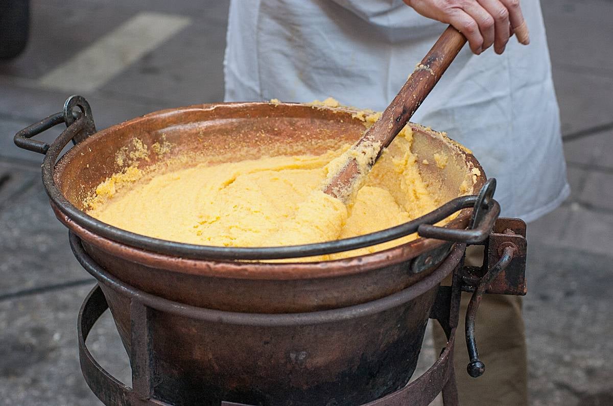 Man preparing polenta in the traditional way from Northern Italy