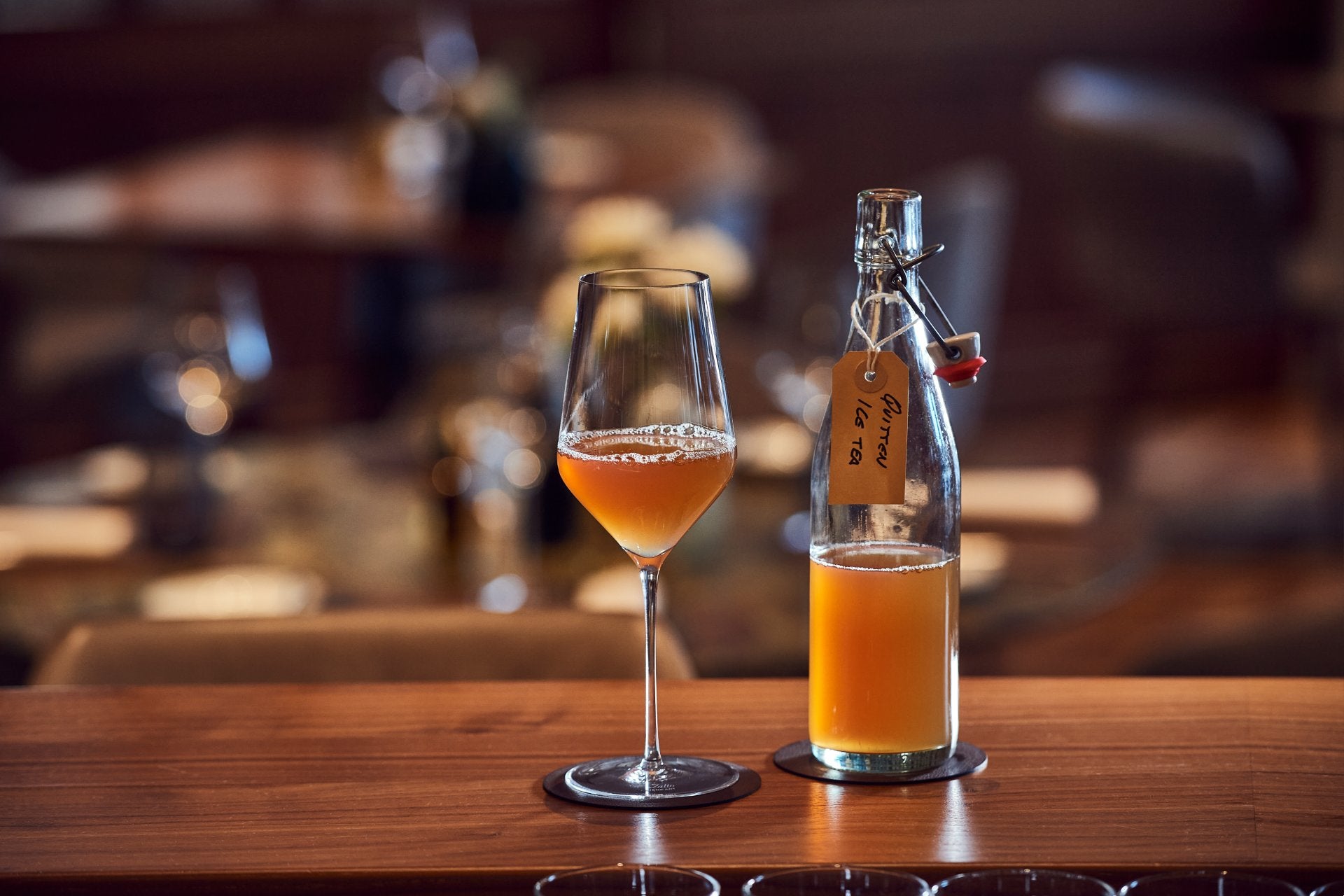 A half full glass and bottle.