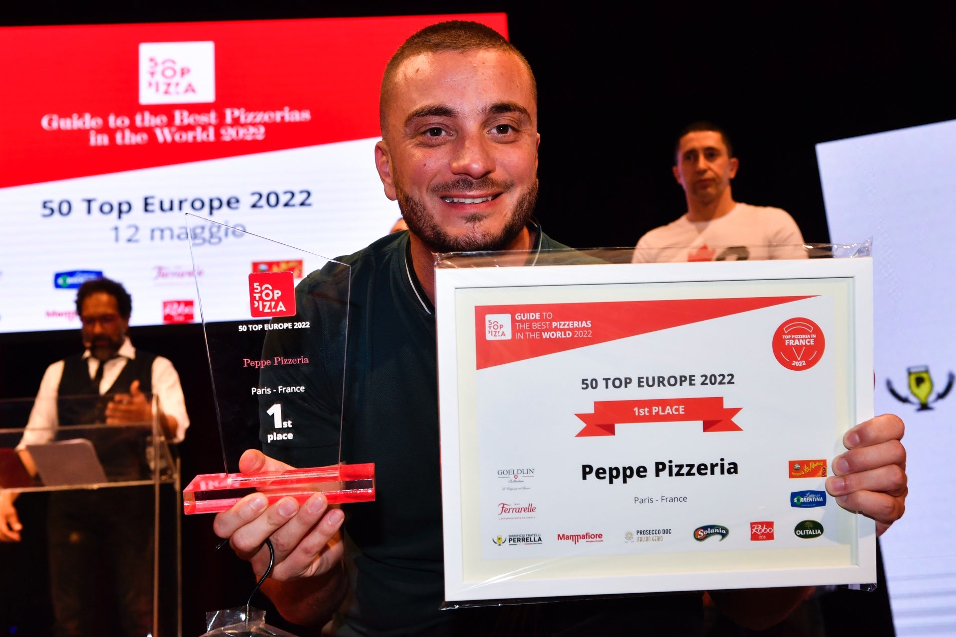 Peppe Cutraro holding up his winning awards