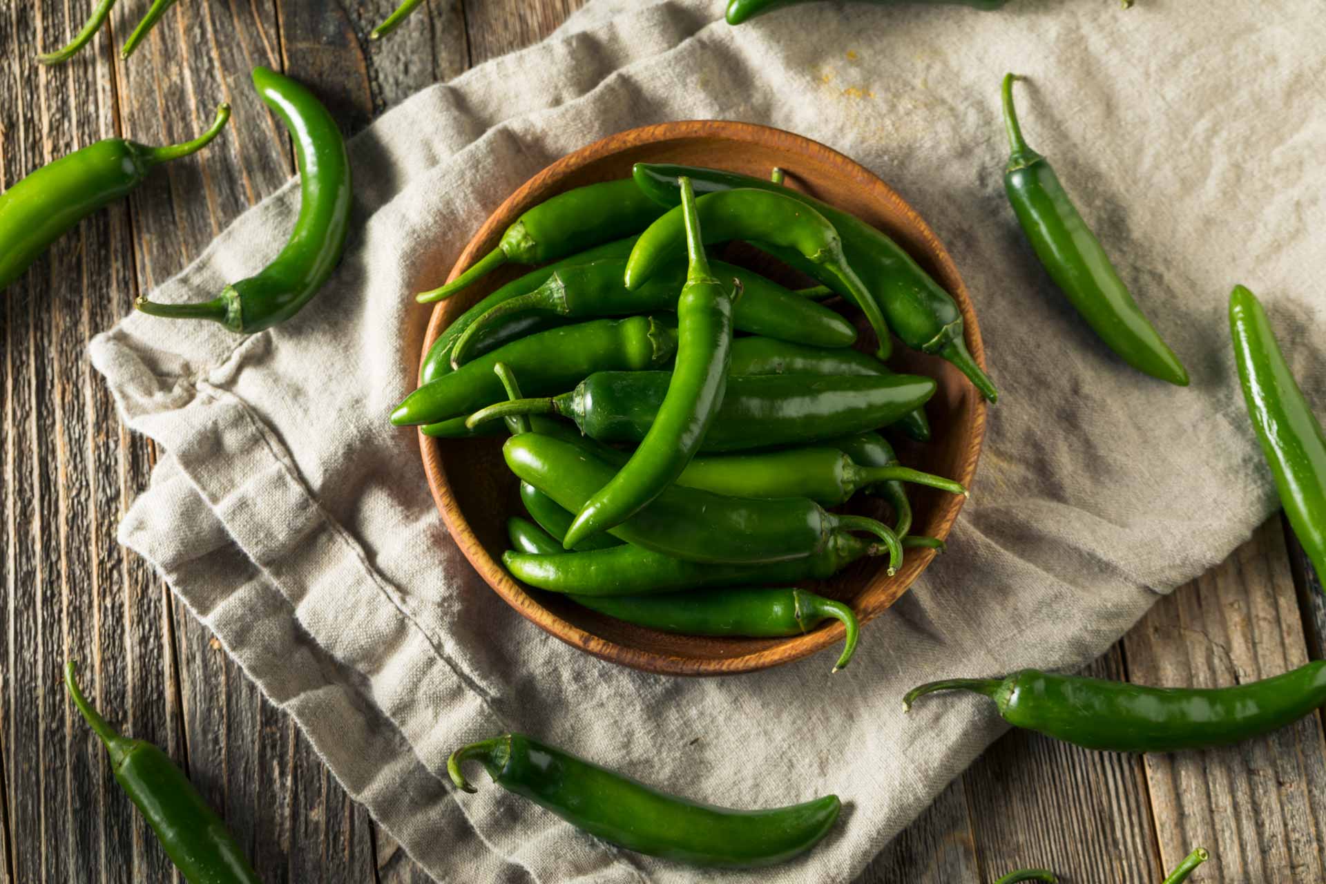 fresh green serrano peppers in a bowl