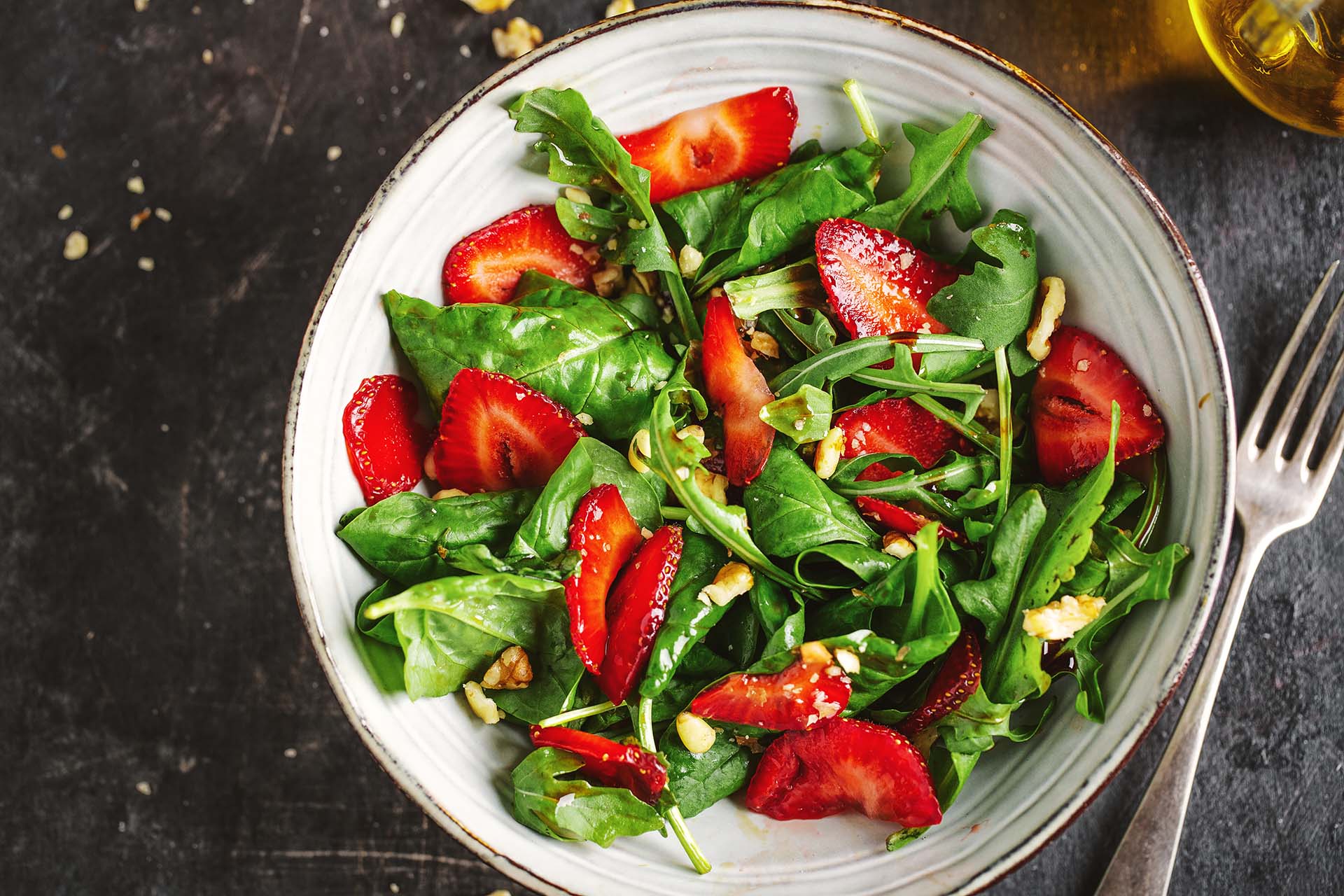 a dish of spinach and strawberry salad