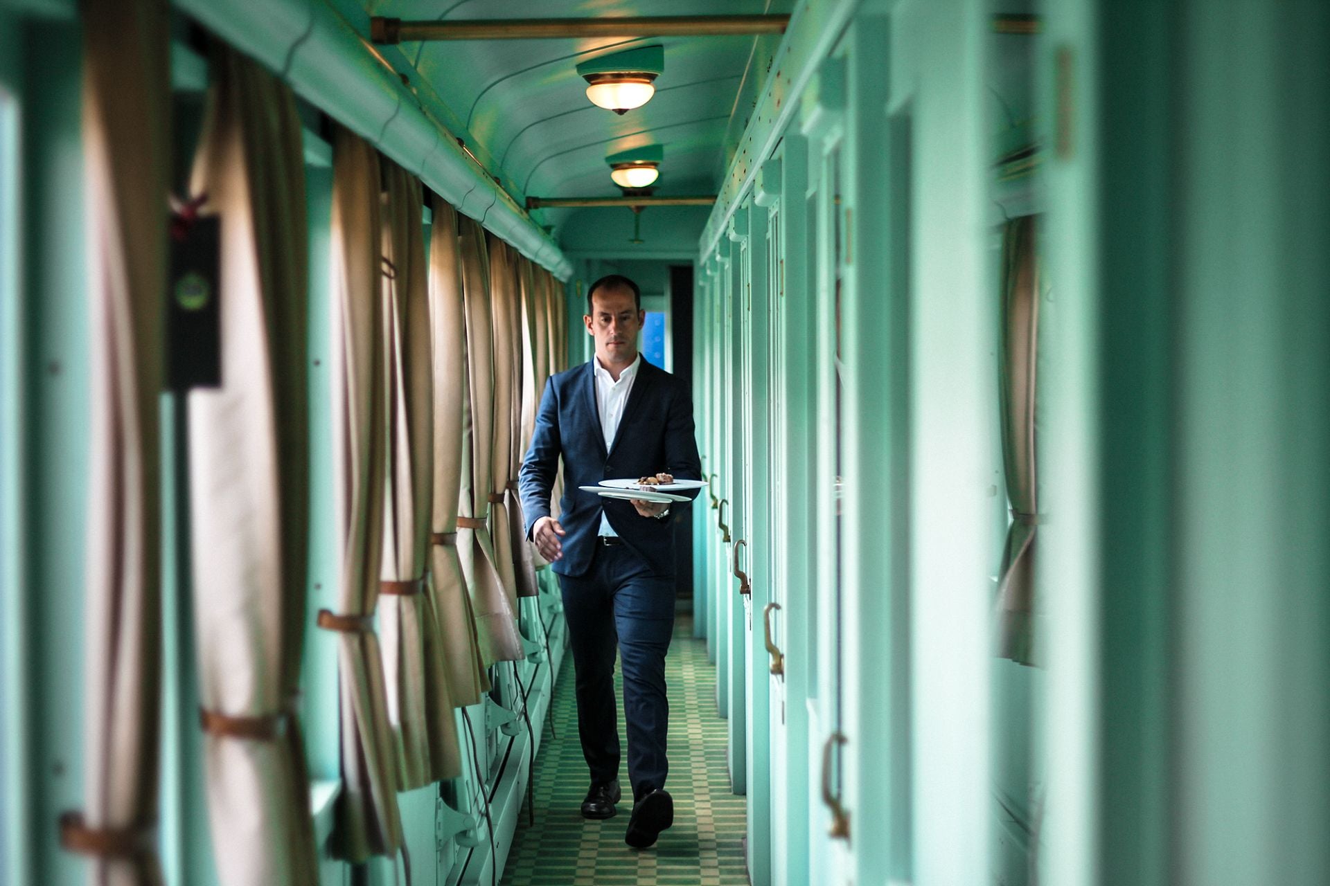 A man walking through a train carriage.
