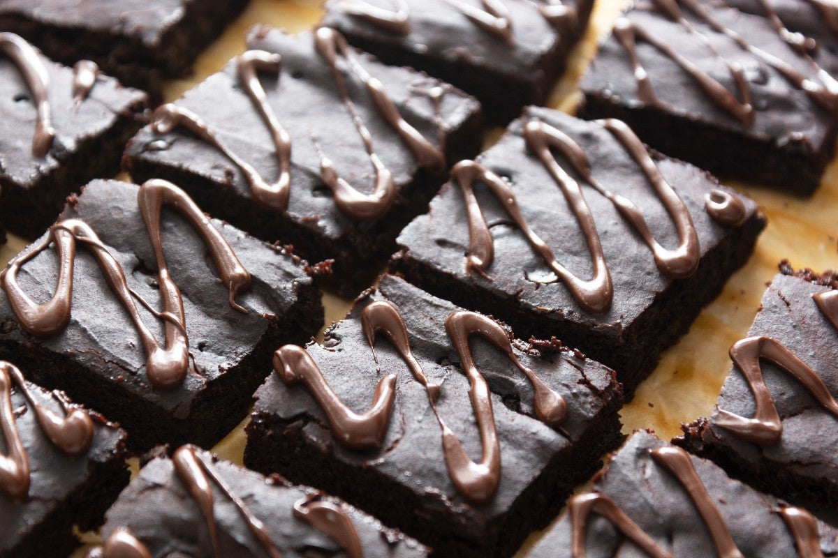 Square slices of chocolate brownies with avocado drizzled with chocolate