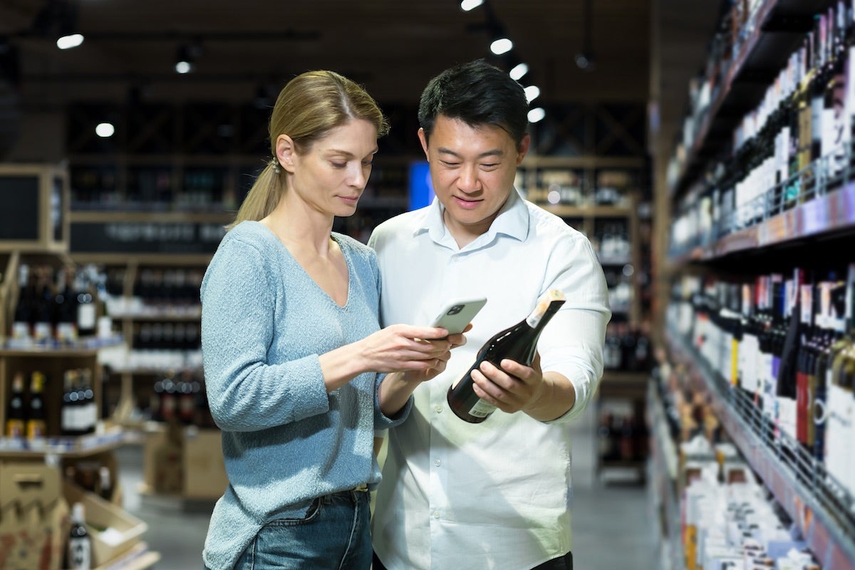 Couple checking wine bottle in a wine store