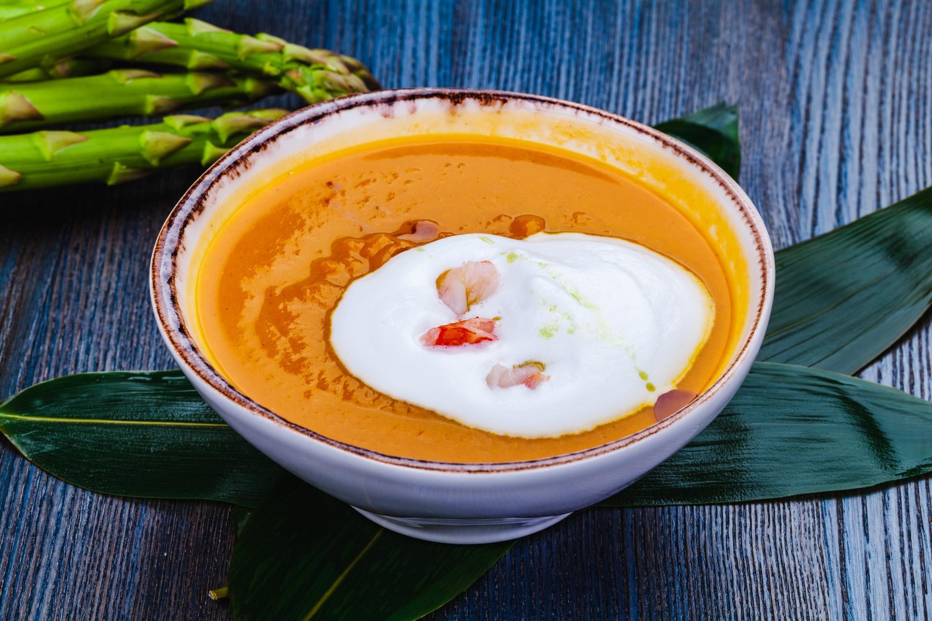 A bowl of velvety bisque topped with a swirl of cream