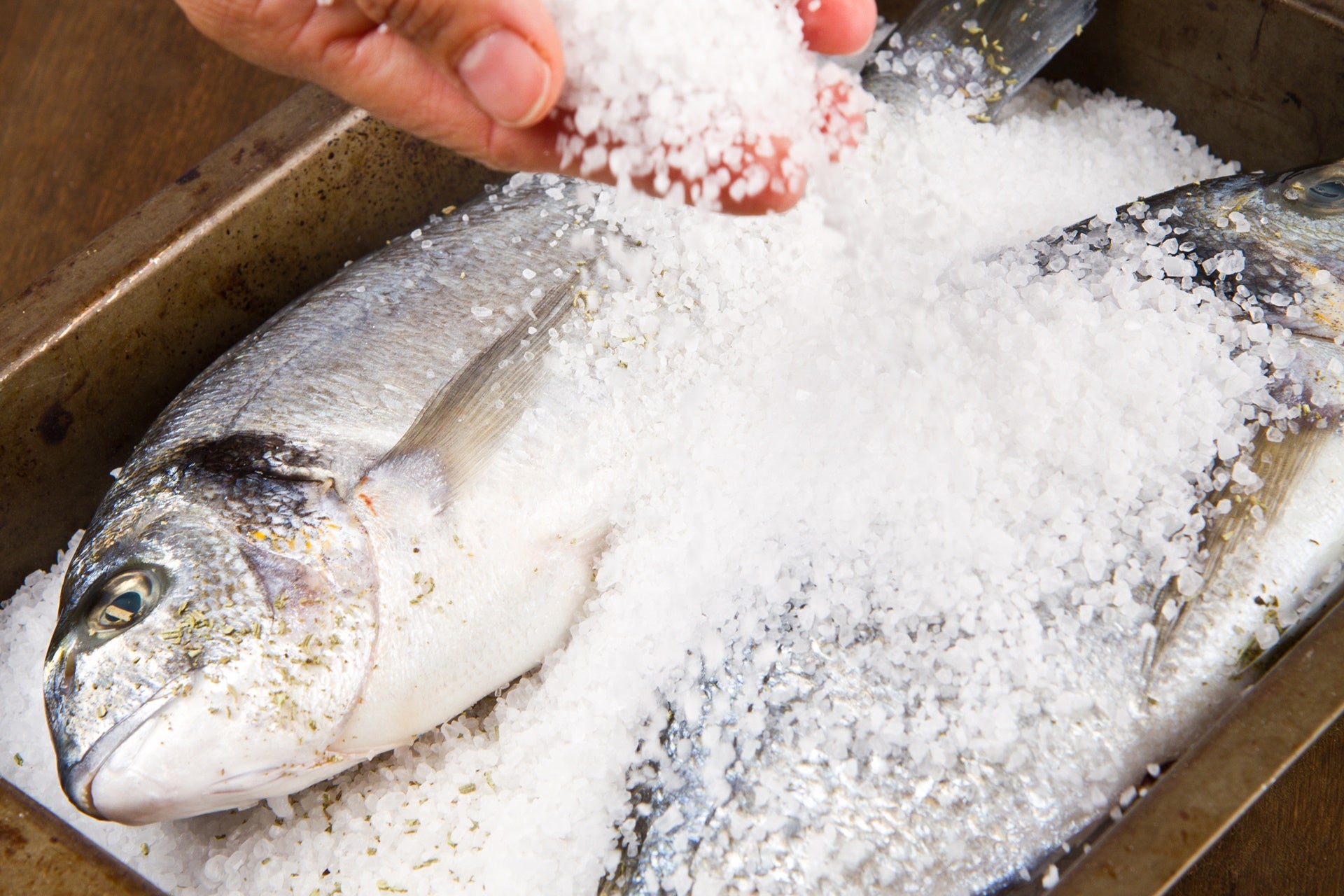 sea bass covered in salt in a baking tray
