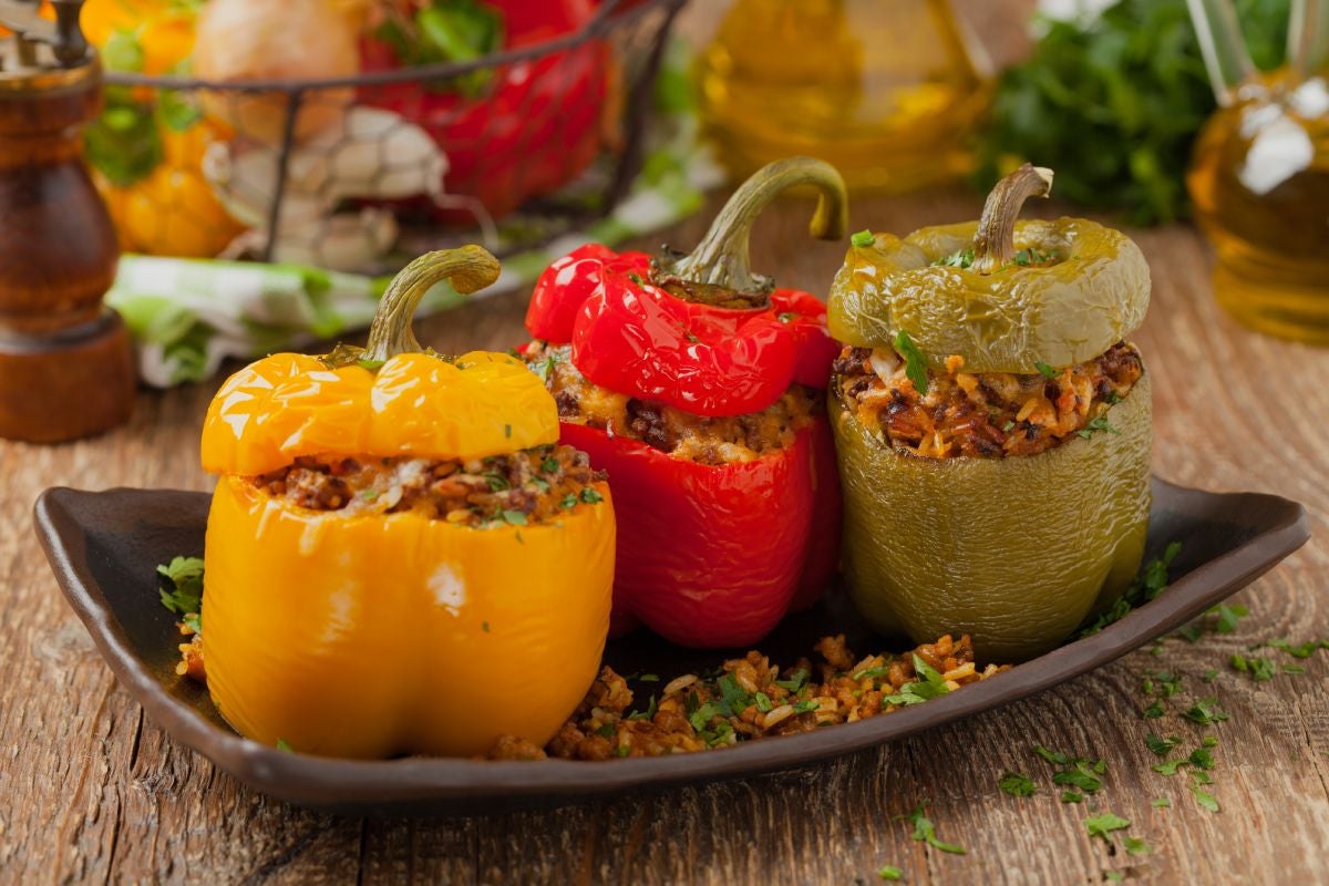Three stuffed peppers with rice and vegetables