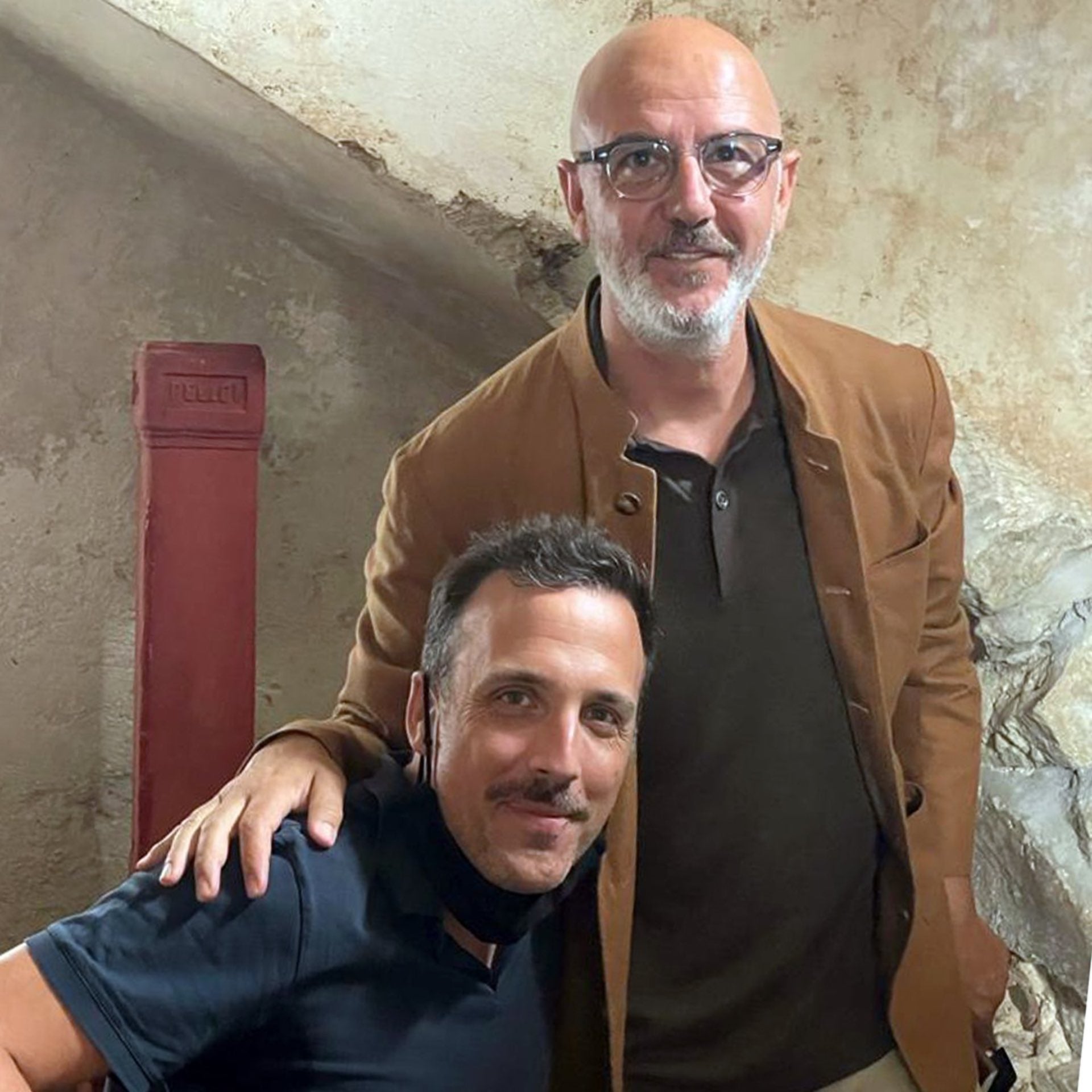 a portrait of two men, one seated, one standing