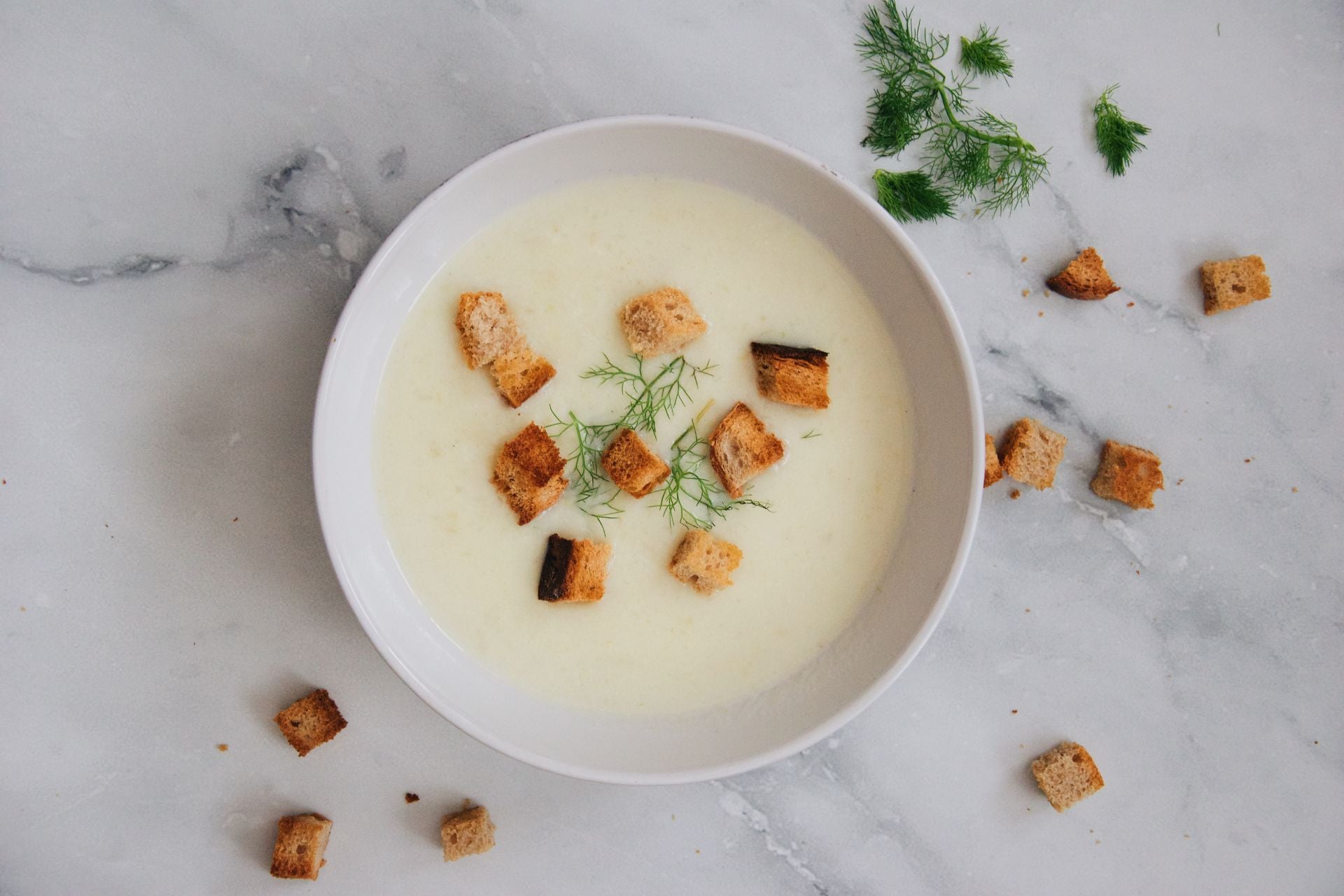 a bowl of soup scattered with croutons