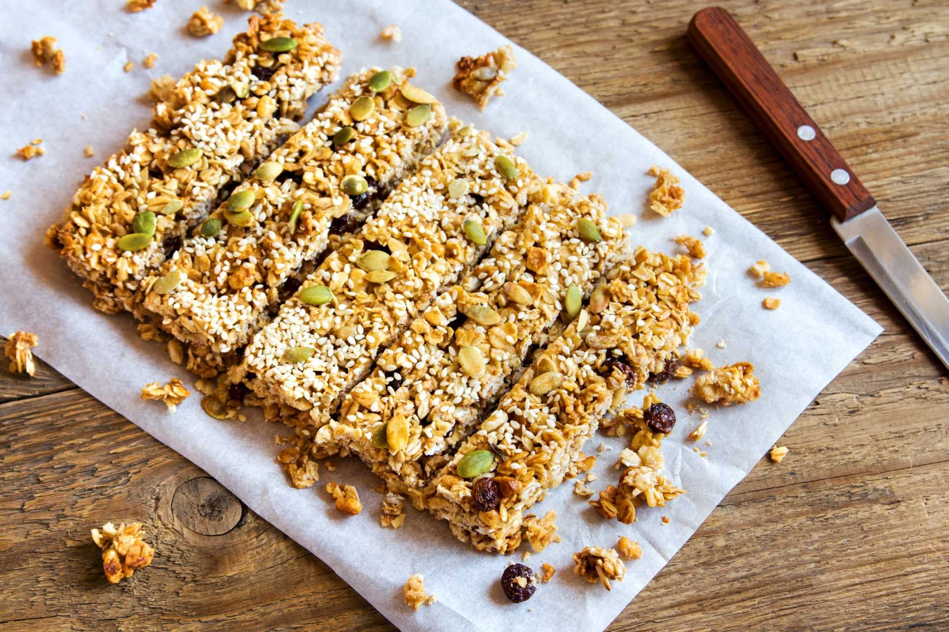 A slap of sliced oatmeal bars topped with chocolate chips and nuts
