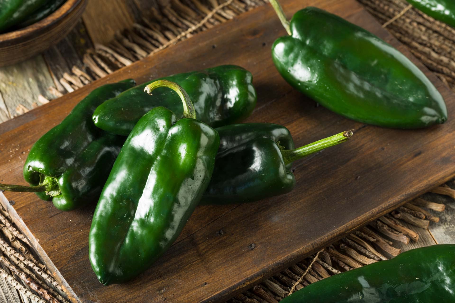 Fresh green poblano peppers on a chopping board