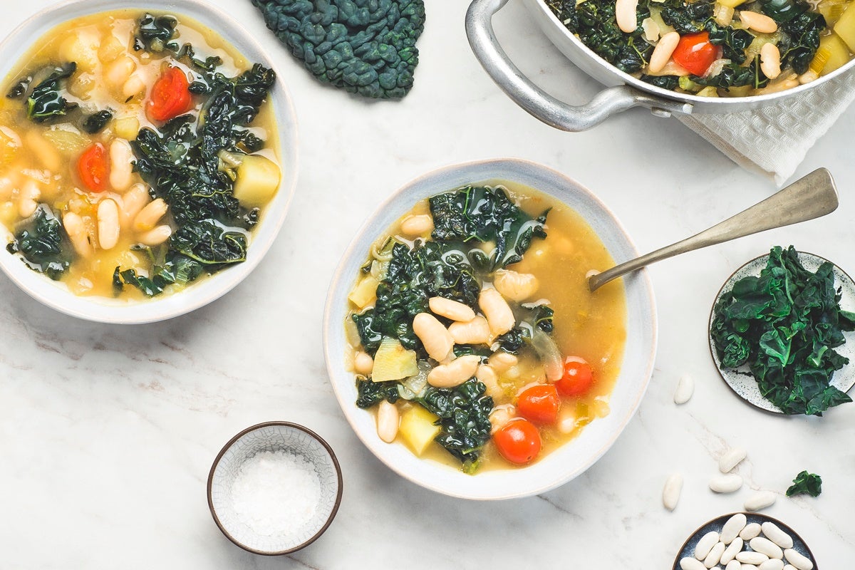 A trio of white bowls filled with fresh ribollita soup