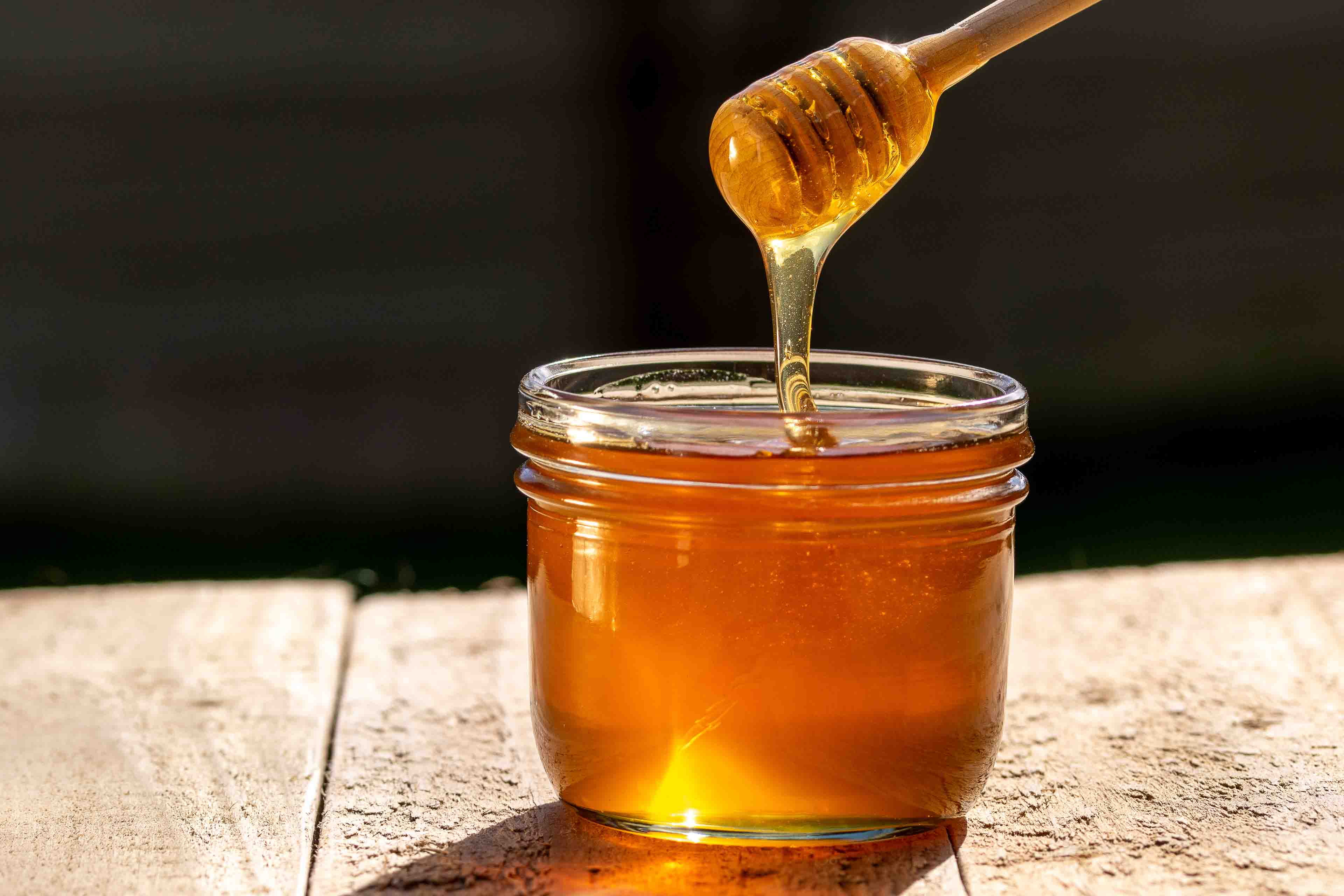 a jar of tupelo honey with a honey dipper