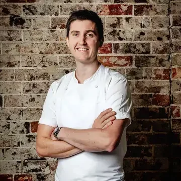 Chef Josh Niland against a brick background.