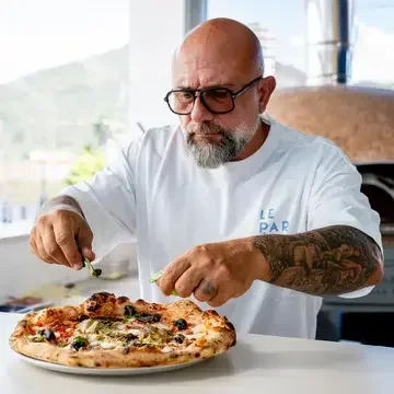 Chef Giuseppe Pignalosa placing toppings on a capricciosa.