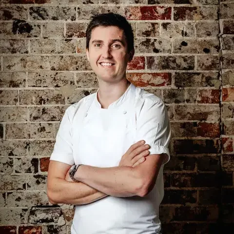 Chef Josh Niland against a brick background.