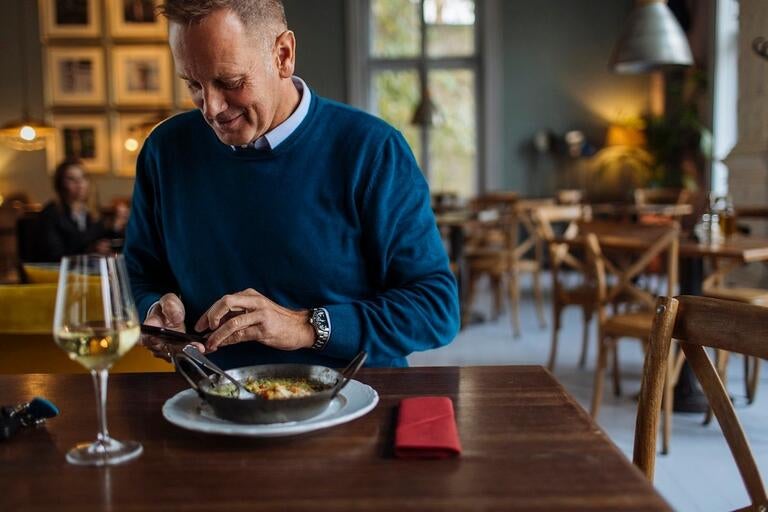 A man looking at his phone while dining.