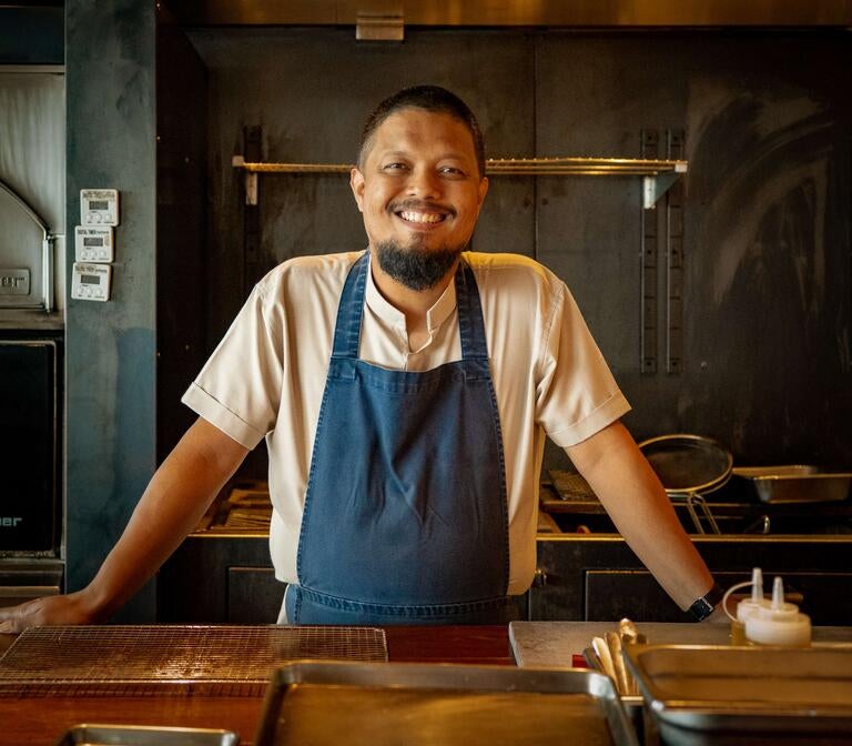 Chef Darren Teoh of Dewakan, smiling in an apron.