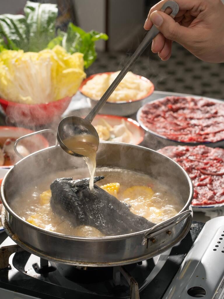 Ladling broth over a hotpot at Big JJ Seafood Hotpot.