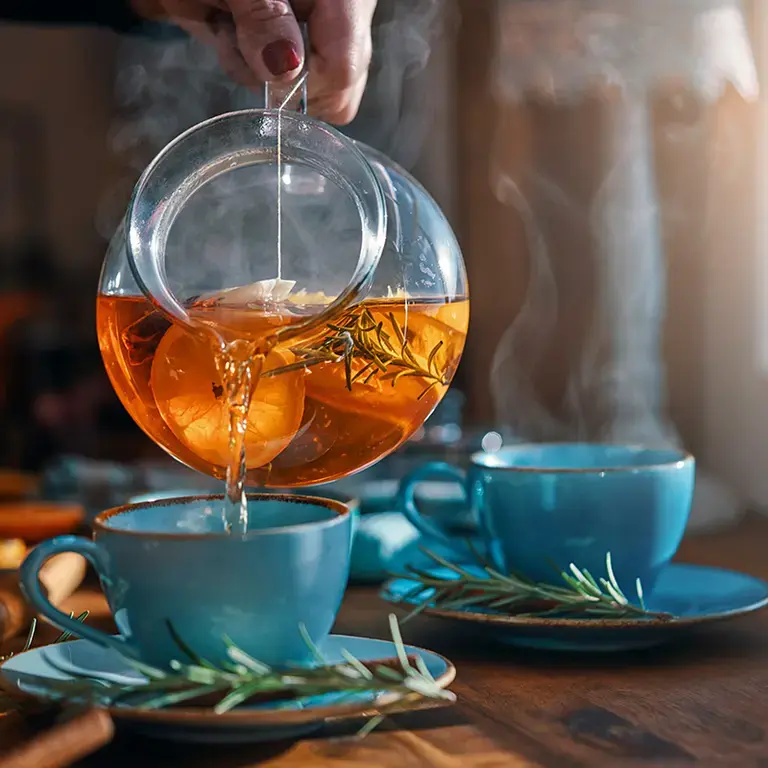 Orange tea being poured into a cup.