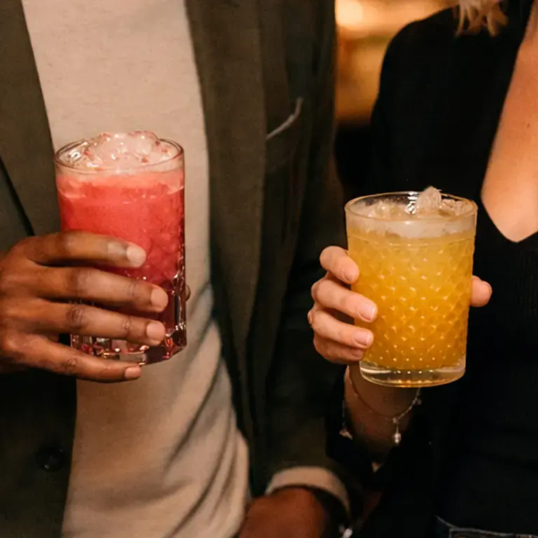 Two people holding mocktails.
