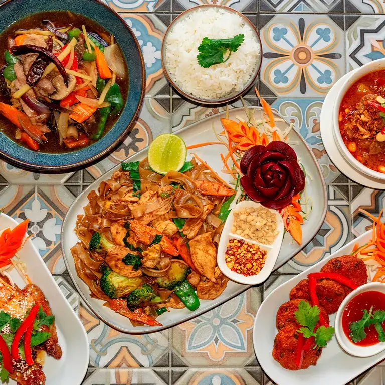 A spread of Thai food on a patterned surface.