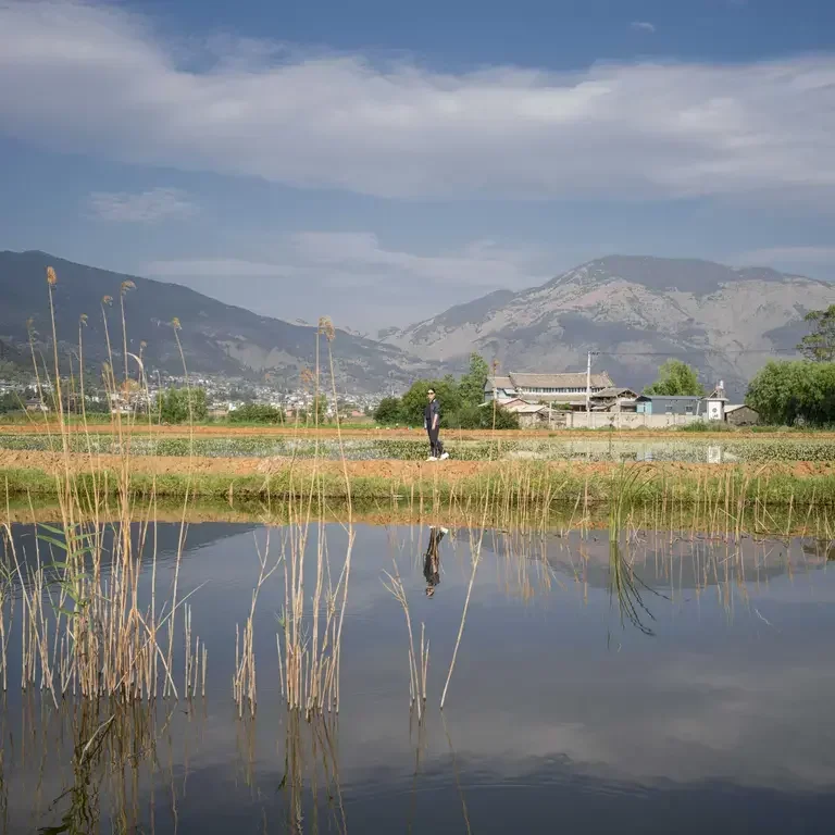 Chef Vicky Lay standing in a flower field in Yunnan.