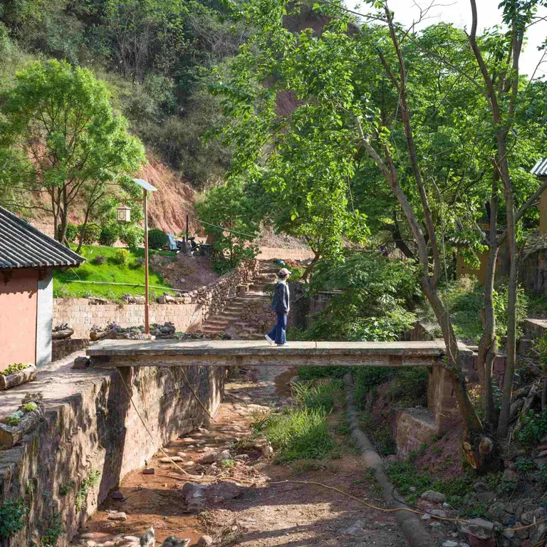 Chef Vicky Lau standing on a simple bridge in Yunnan.