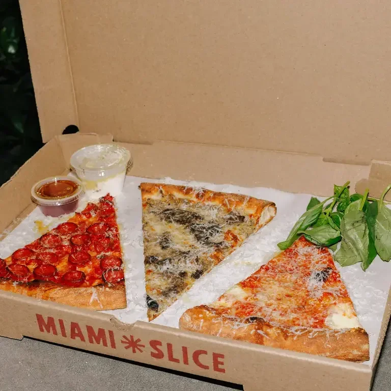 Three different slices of Miami Slice pizza in a box.