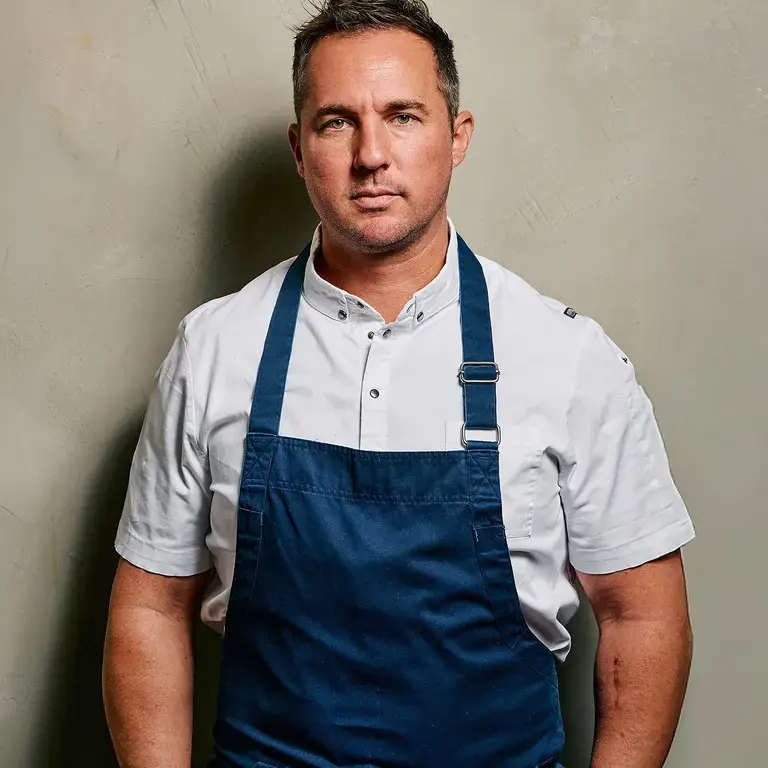 Chef Clinton Mciver in a blue apron.