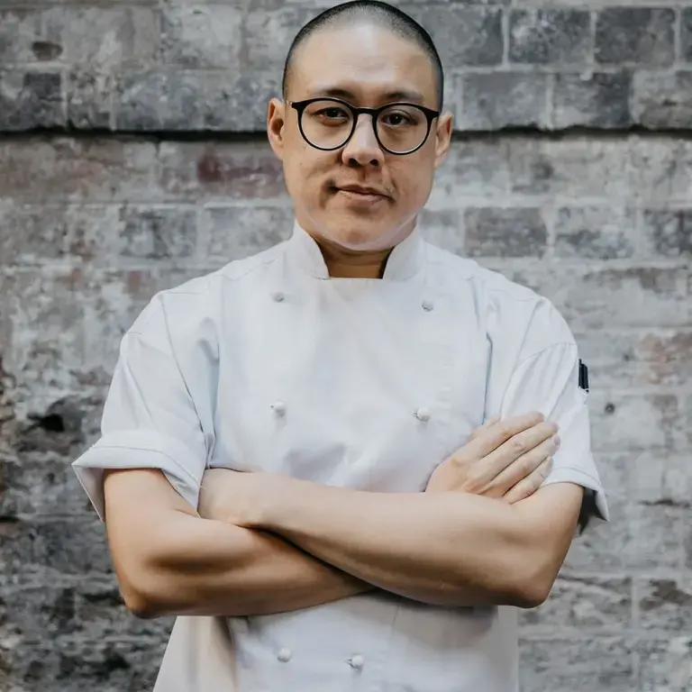 Dan Hong in chef whites with his arms folded.