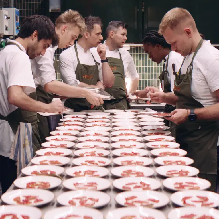 Chefs preparing multiple dishes at Firecat.