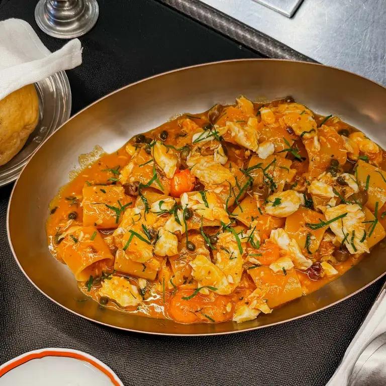 Paccheri with seabass in a metal pan.