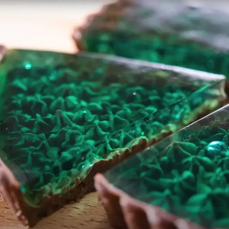 a slice out of a transparent green chocolate tart