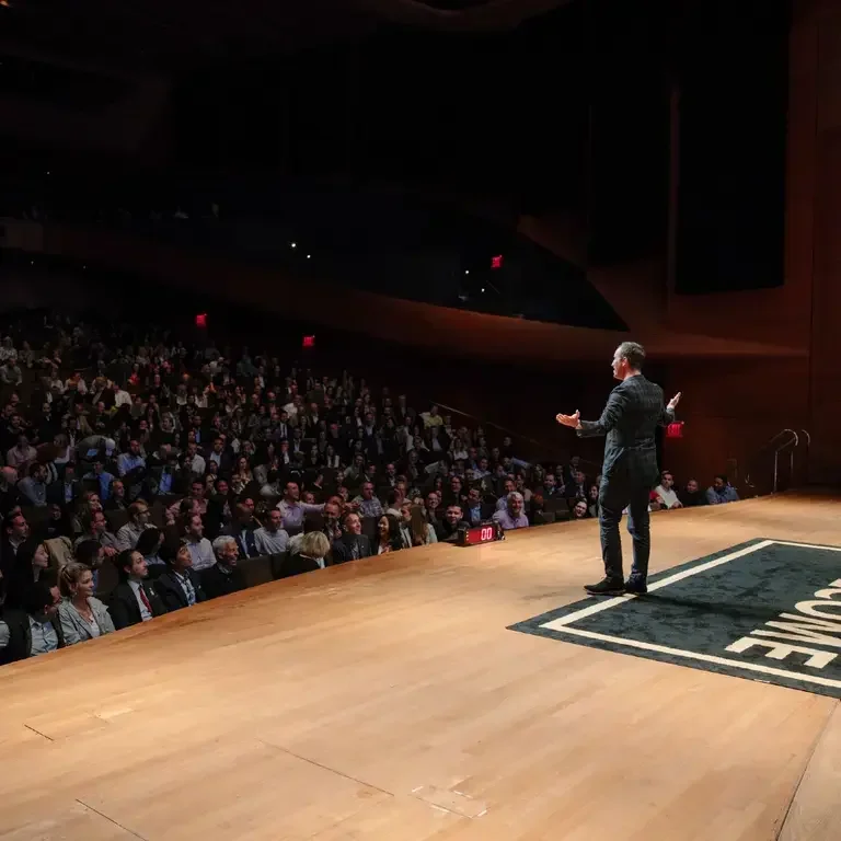 Will Guidara on stage presenting to a packed theatre