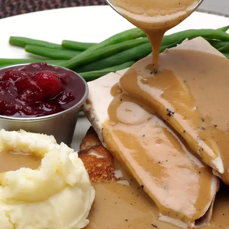 pouring gravy on plate ©iStock