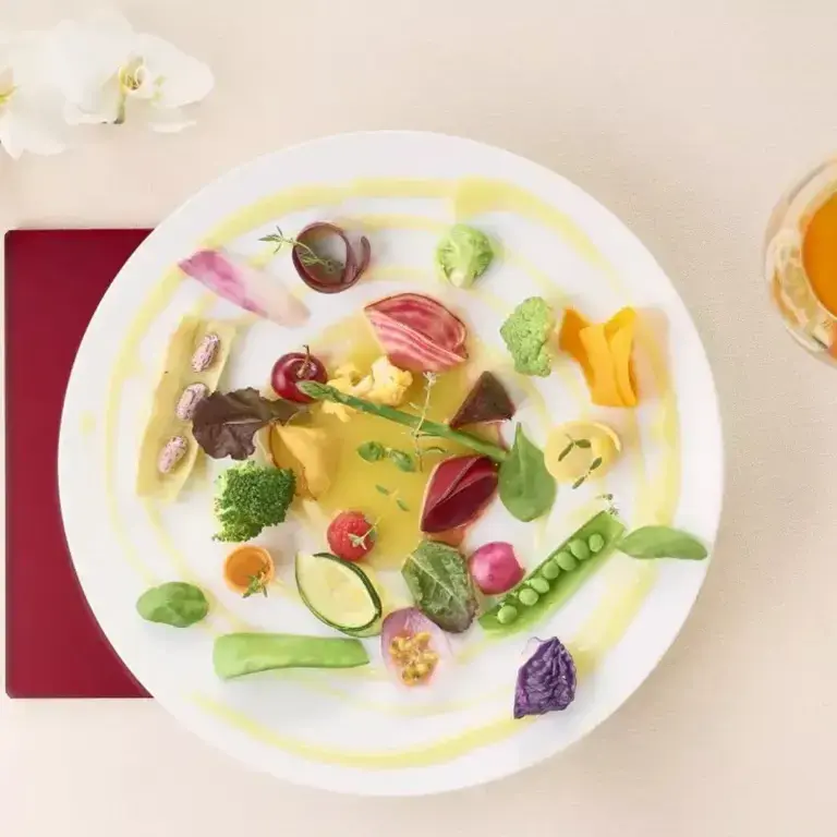 a colourful fine dining dish against a white background
