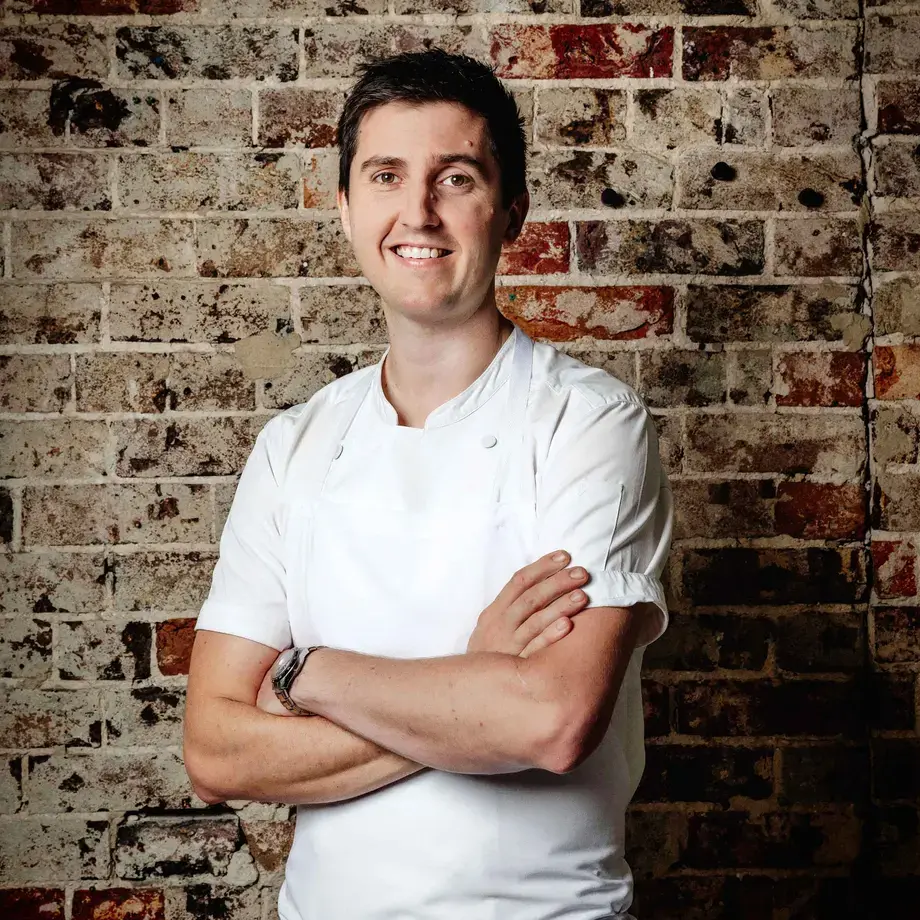 Chef Josh Niland against a brick background.