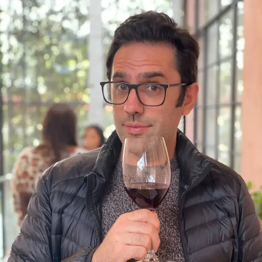 Journalist Paul Feinstein holding a glass of red wine.