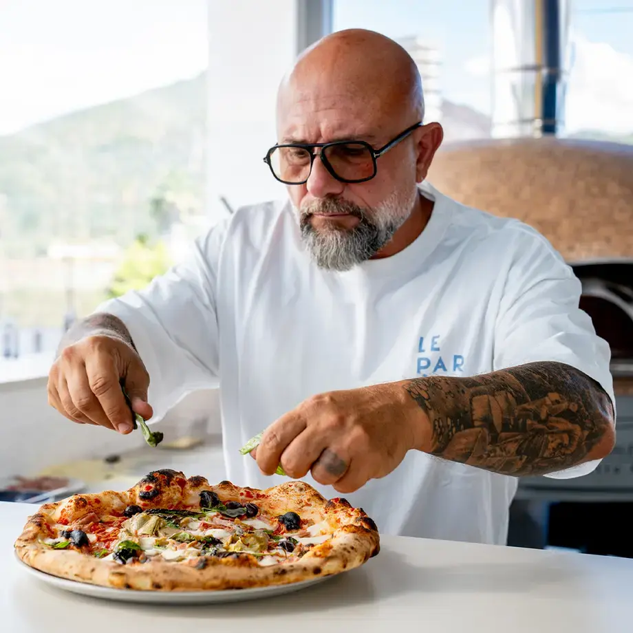 Chef Giuseppe Pignalosa placing toppings on a capricciosa.