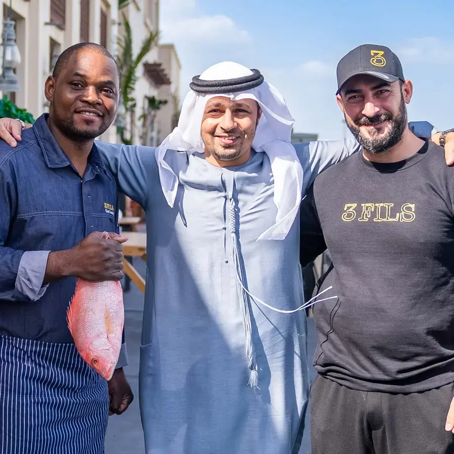 Three men smiling at the camera.
