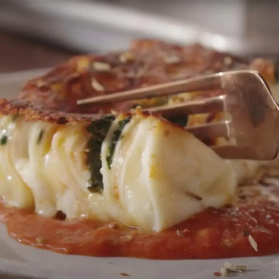 A fork cutting into a 24 layer lasanga on a plate