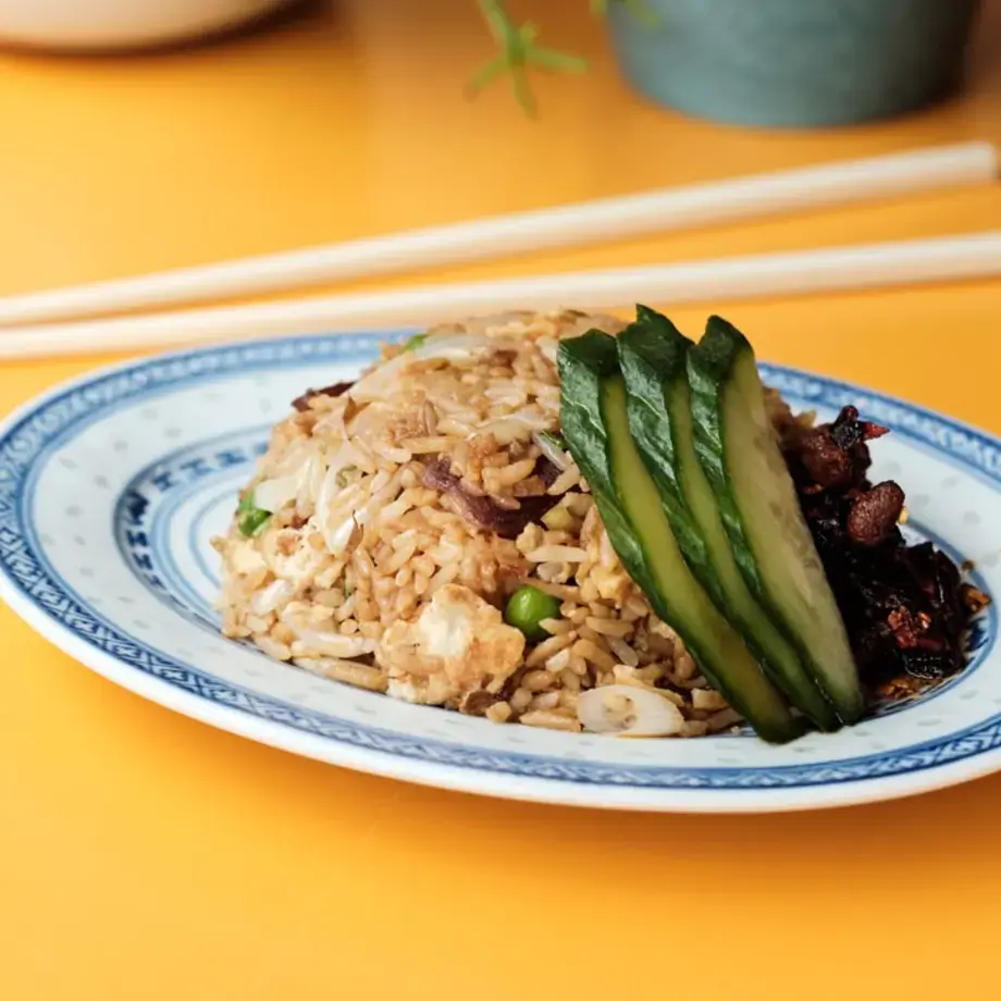 A plate of food on a yellow table with chopsticks.