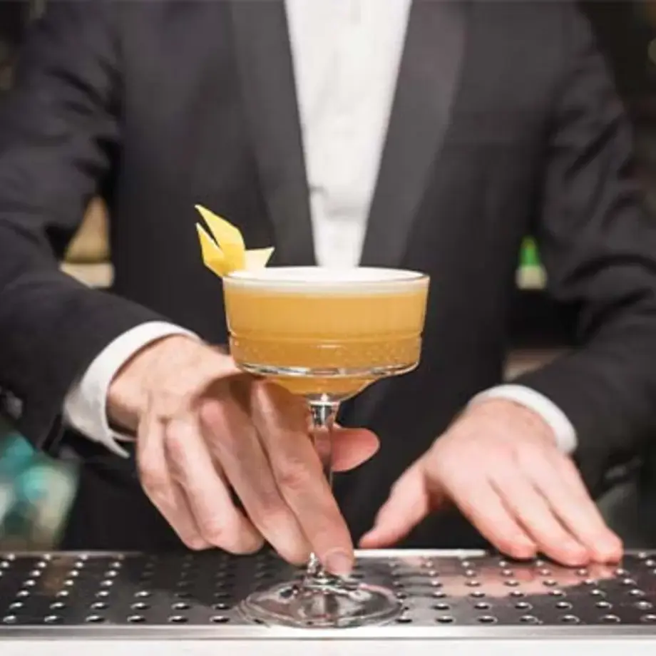 an amaretto sour cocktail served on the bar in a champagne coupe
