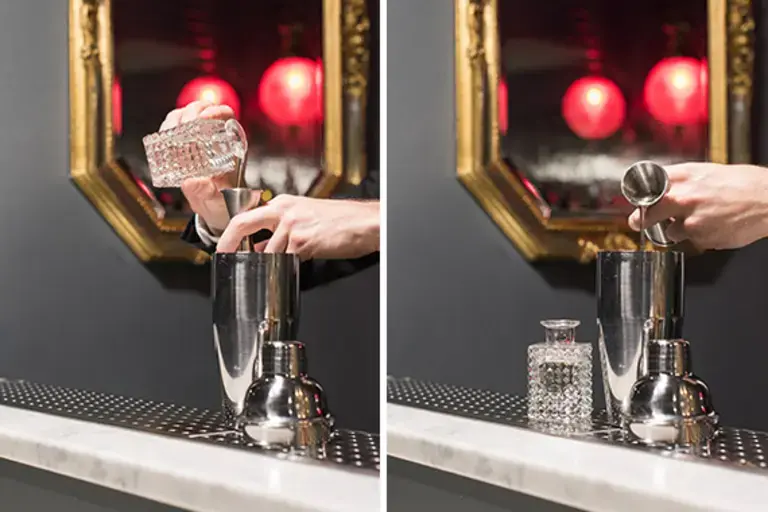 a hand measuring sugar syrup into a jigger