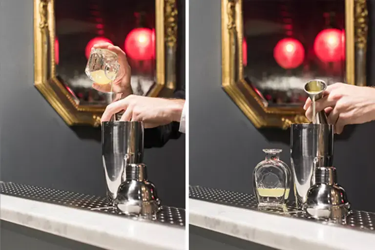 a hand measuring egg white into a jigger