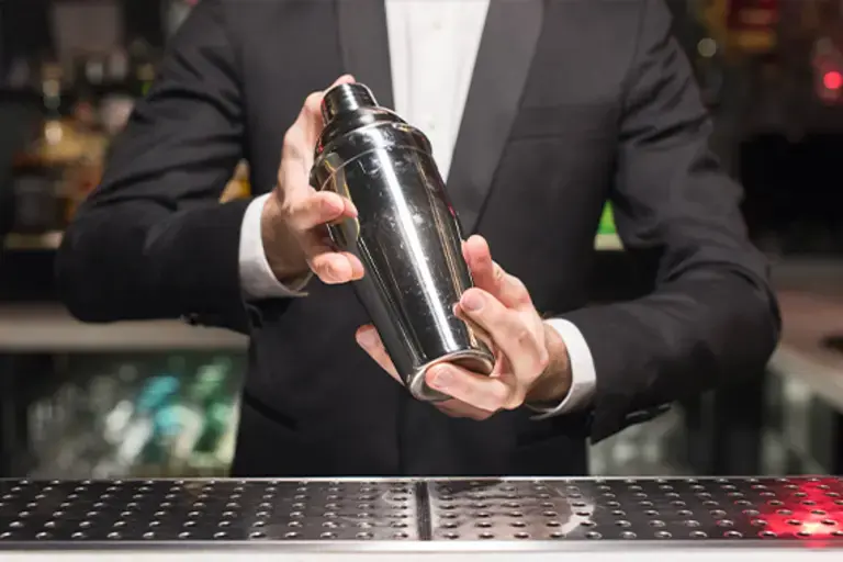 a barman shaking a closed jigger