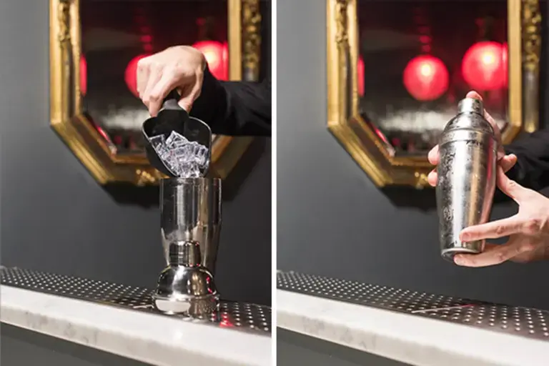 a hand adding ice to a jigger, closing and shaking