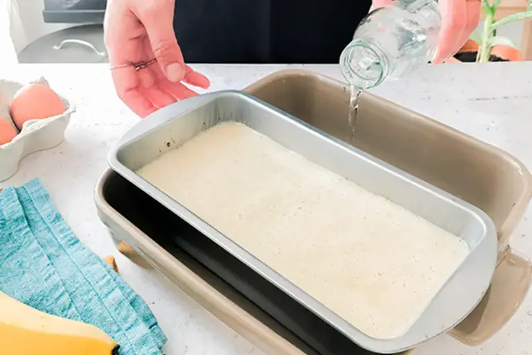Preparing a bain marie with the banana mix in tin