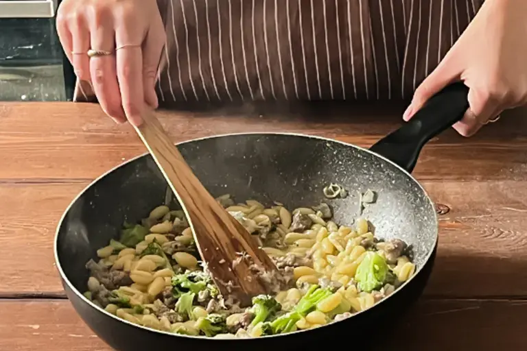 Chef stirs the mixture in the pan.